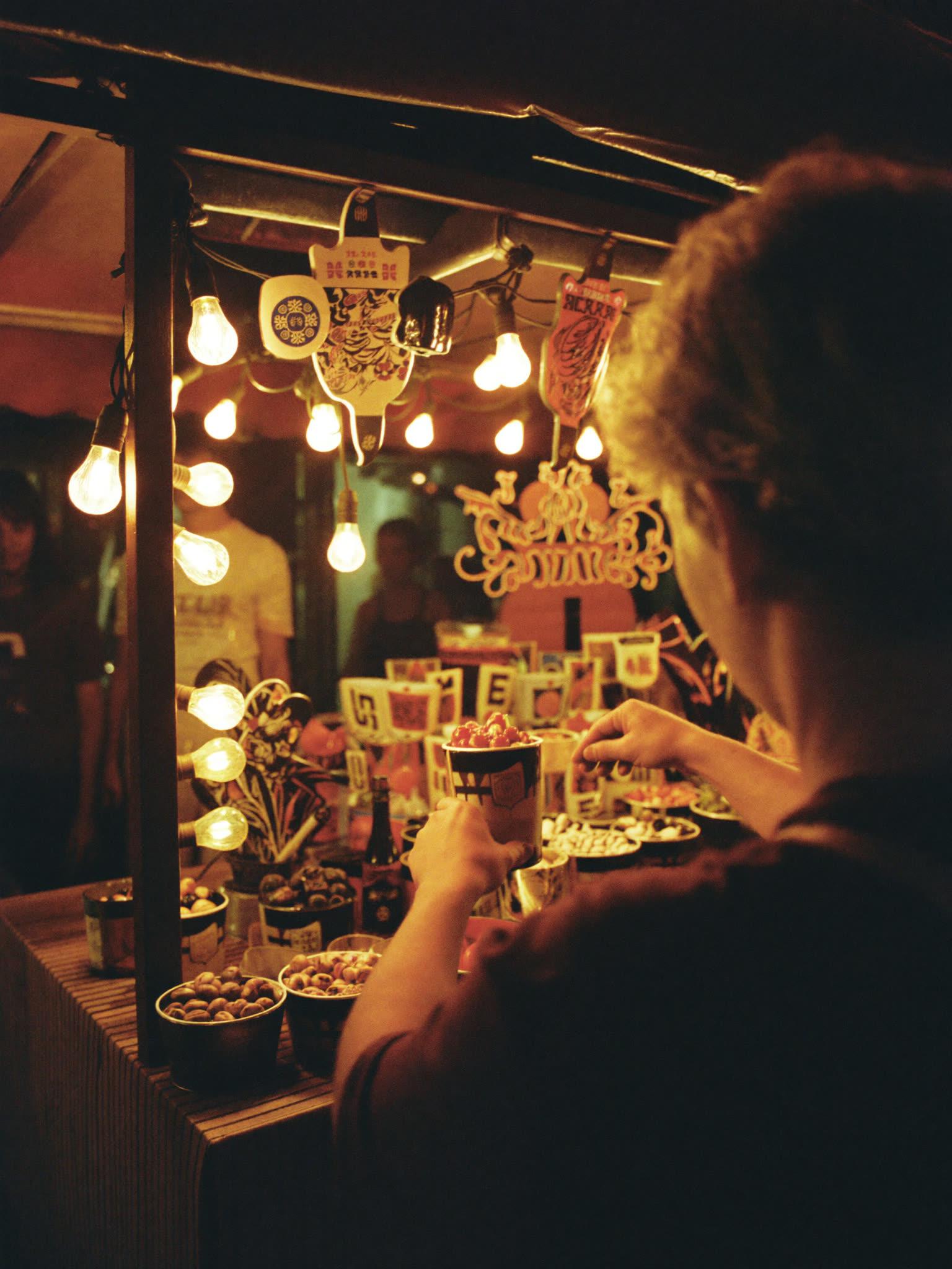 A night-market vendor stall glowing under string lights